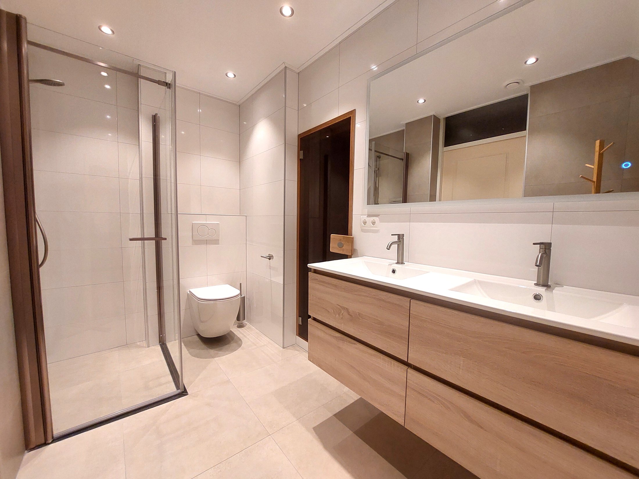 Badkamer met inloopdouche, toilet en dubbele wastafel